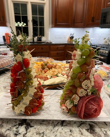 Christmas party ideas. Christmas charcuterie trees with salami roses at the base. I used mozzarella, grapes, tomatoes, olives and some premade charcuterie bites. Wrap the foam in foil first and use thyme to fill it in! 

#LTKSeasonal #LTKHoliday #LTKparties