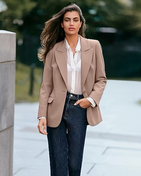 Looking for timeless autumn outfit for workwear in the UK? This chic fall look pairs a beige tailored blazer with a crisp white shirt and dark wash jeans — the perfect smart casual outfit for work, city strolls, or dinner out. A classic combination that works for both autumn and fall fashion trends, giving you effortless elegance with minimal effort.