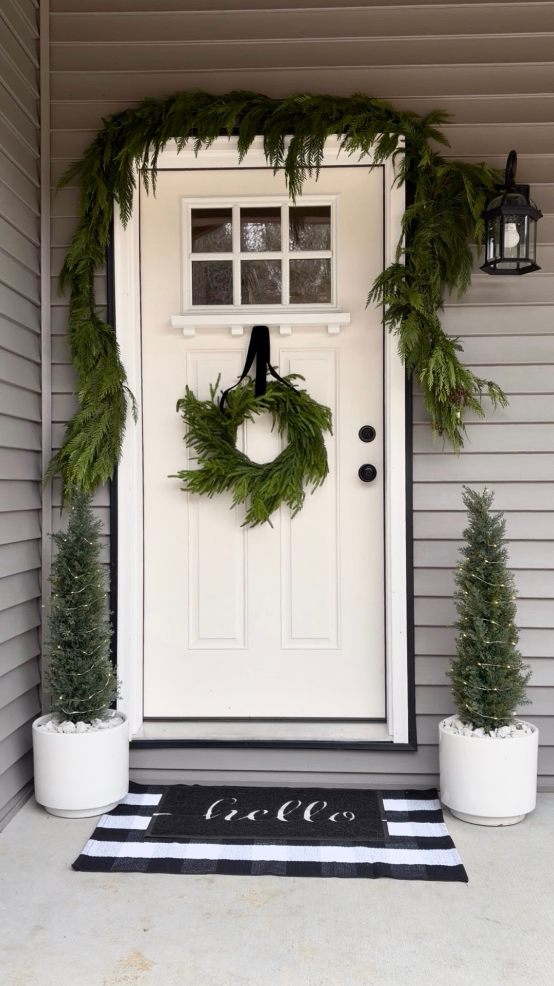Christmas curb appeal, but make it timeless ✨🎄
A cozy mix of classic + modern: a 10-ft real garland, real-feel wreath finished with a chic 2” black ribbon, two 3-ft cedar trees, twinkling remote-control fairy lights, layered black & white plaid rug, and a simple hello black doormat.

Proof that a few intentional pieces can turn a front porch into a holiday moment worth slowing down for.
✨ Save for inspo Shop today

#ChristmasPorch #HolidayDecor #FrontPorchDecor #OutdoorChristmas #ClassicChristmas #ModernCottage #FarmhouseChristmas #BlackAndWhiteDecor #CurbAppeal #ChristmasInspiration

#LTKSaleAlert #LTKHoliday #LTKHome