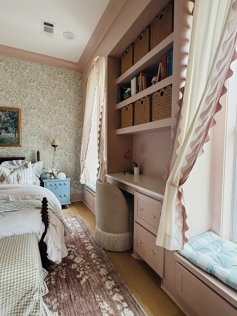 🌸 Blush built-ins + ruffles = little girl’s room dreams!
This cozy reading nook and homework station is giving vintage charm meets function. Loving the scalloped curtains, fringe desk chair, and those woven baskets keeping it all tidy. 🧺💗

🪞 Shop the look:
– Pink built-in desk + brass knobs
– Scalloped curtains with blush trim
– Velvet fringe desk chair
– Mauve vintage-style rug
– Blue gingham window cushions
– Woven storage baskets
– Floral wallpaper + blue nightstand

Perfect for a soft, traditional bedroom with English countryside influence.

#LTKhome #girlsbedroomdecor #southernstylehome #pinkbuiltins #scallopedcurtains #fringechair #vintagegirlsroom #ltkdesksetup #homeorganization #cottagecoredecor #englishcountryinterior #organizedkidsroom

 

 #LTKHome
