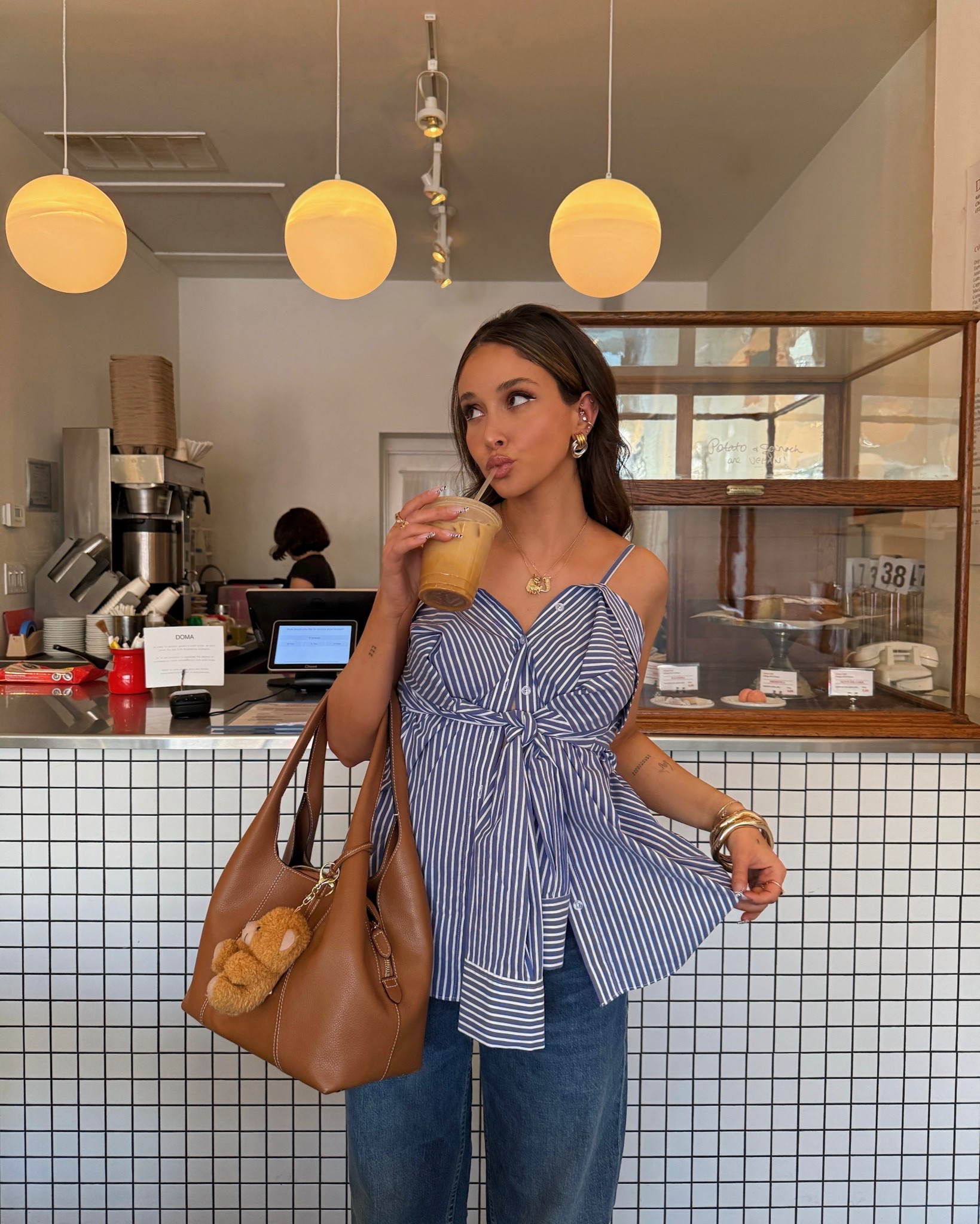 early spring outfit ideas, coffee shop aesthetic, revolve button up striped tie top, blue baggy denim, brown bag, teddy bear bag charm 

#LTKSpringSale #LTKSeasonal #LTKStyleTip