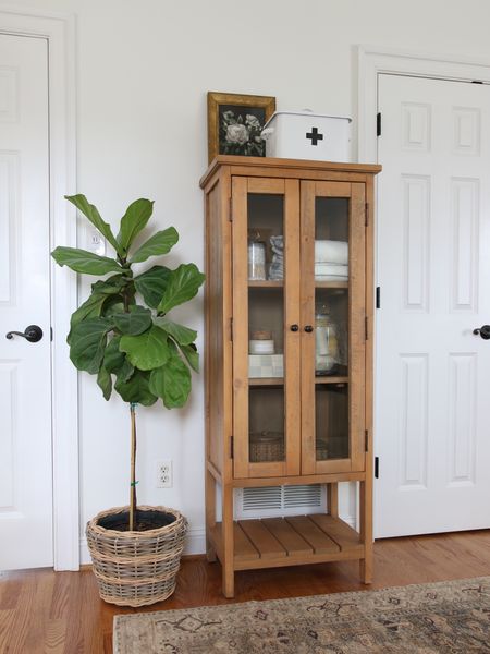 I had originally gotten this rustic wood linen closet for my primary bathroom remodel but it did not quite work so I placed it in this bedroom. It can be decorative or practical. 
This shelf decor includes, an enamel decorative first aid box, floral framed wall canvas, checkered resin box and mini glass apothecary jars

#LTKFind #LTKhome #LTKstyletip