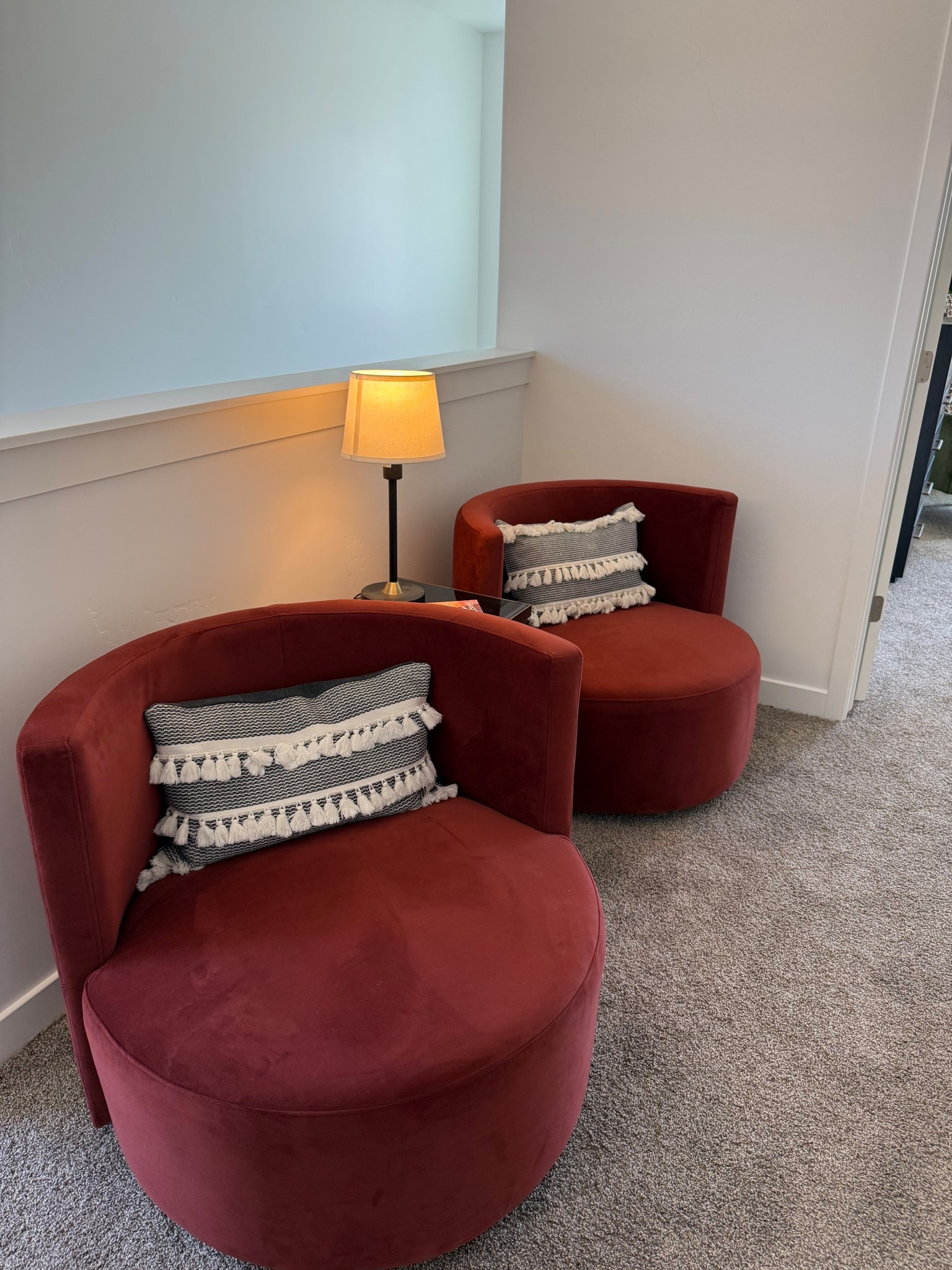 Cozy up at the top of the stairs in this inviting reading nook! Featuring plush burgundy swivel chairs, textured tassel pillows, and the soft glow of a warm lamp, this space is perfect for morning coffee, quiet moments, or getting lost in a good book. A stylish and serene corner that proves small spaces can be both functional and beautiful. #ReadingNook #HomeInspo #CozyCorner #StairLandingIdeas #InteriorDesign 

#LTKHome #LTKStyleTip