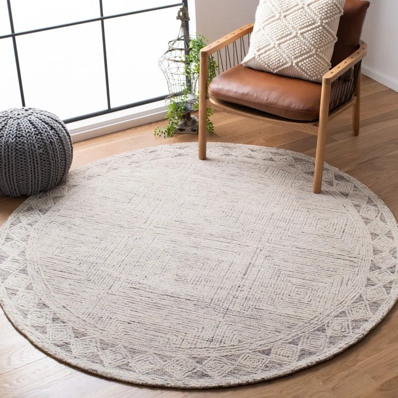 Loving this cozy neutral reading nook featuring a hand-tufted round wool rug from Wayfair, paired with a warm brown leather accent chair, textured cream throw pillow, and chunky knit pouf. The subtle geometric pattern and soft ivory tones make this rug a beautiful foundation for living rooms, bedrooms, and cozy corners. Currently 61% off, it’s an easy way to add warmth, texture, and timeless style to your space.