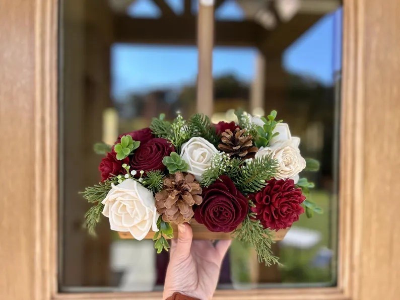 Bring timeless holiday charm to your home with this best-selling wood flower centerpiece from TetonWoodBlooms. Handcrafted with beautifully carved wood blooms, cedar, pine, and baby’s breath, each arrangement features unique flowers set in a rustic dark brown wood box. Choose up to two custom colors—paired with classic ivory roses—to create a winter look that feels perfectly you. Available in three sizes, this made-to-order piece adds a warm, seasonal touch to tables, mantels, and holiday gatherings while lasting beautifully year after year. 🎄✨
#LTKholiday #etsyhome #woodflowers #christmascenterpiece #rusticdecor #winterdecor #handmadehome #seasonalstyle

#LTKHome #LTKHoliday #LTKSeasonal
