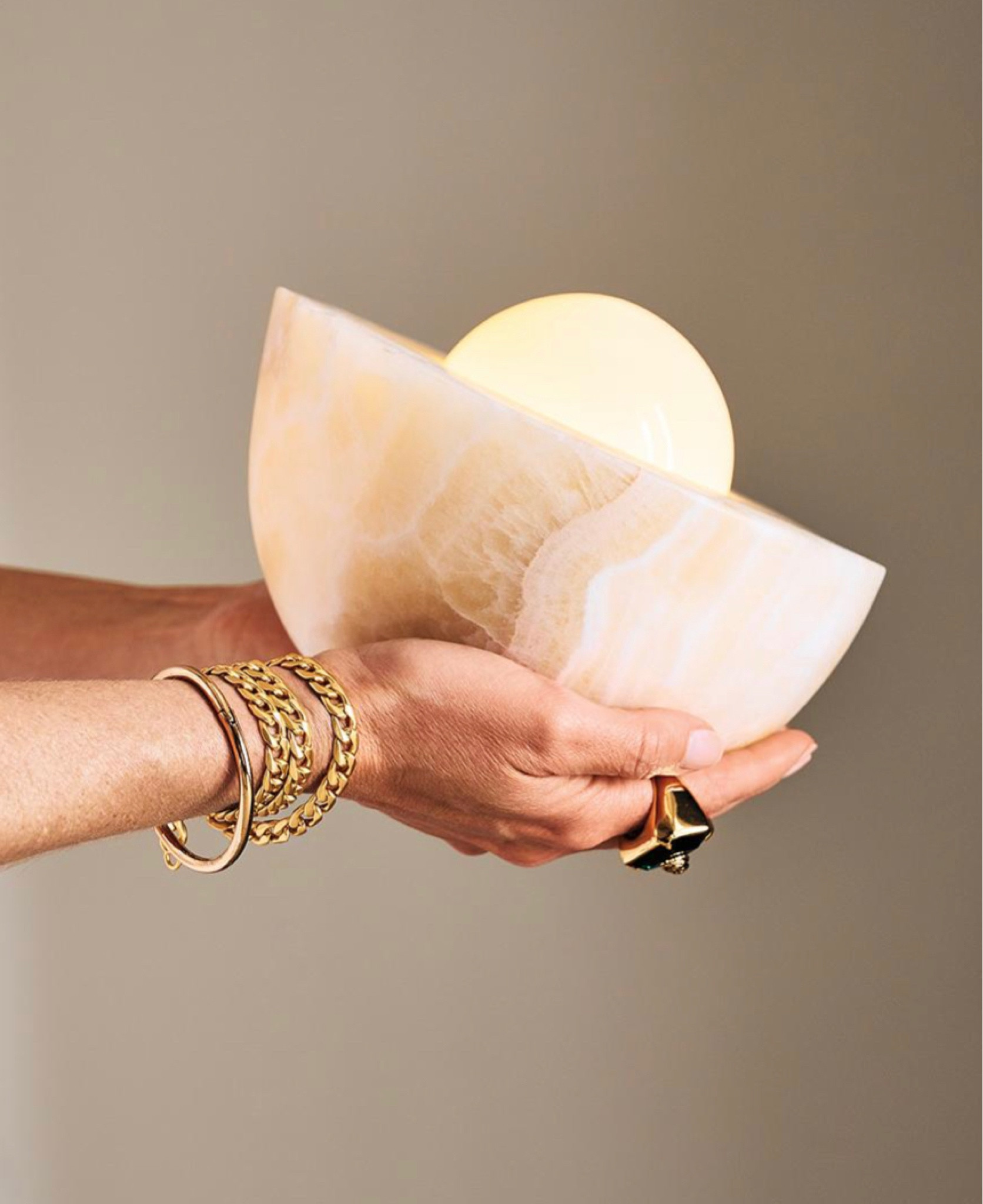 Cream onyx creates a strong silhouette for Jannis Ellenberger's minimalist table lamp. Inspired by an oyster shell gently cradling a pearl, a softly rounded hemisphere of solid cream onyx creates a sculptural base, while a sleek opaline glass globe shade sits within, casting a warm glow. Small in scale, the fixture beautifully lights up smaller spaces like a bookshelf or office desk. 

#LTKhome #LTKGiftGuide