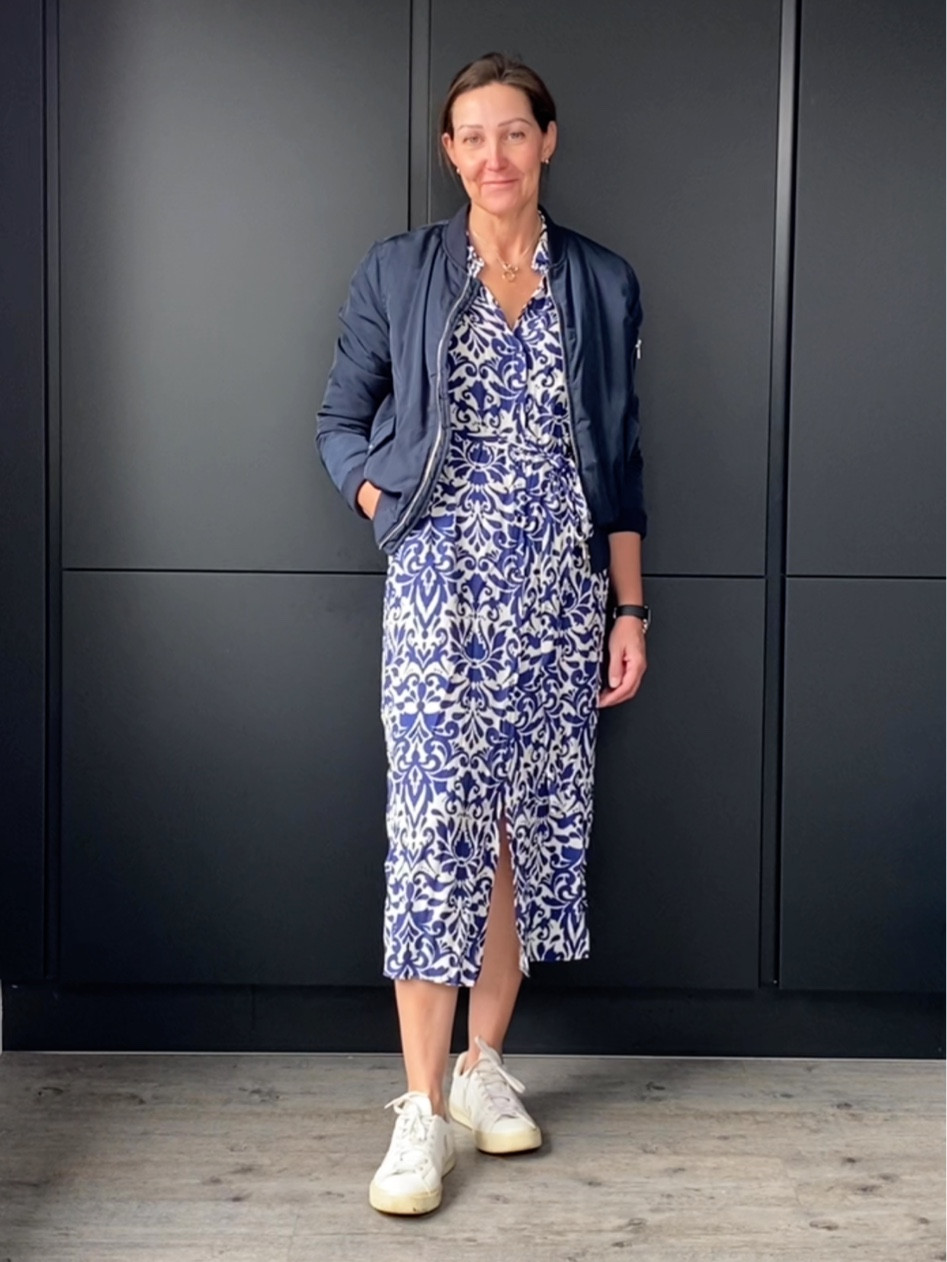 Spring bomber jacket styling over a printed midi dress
