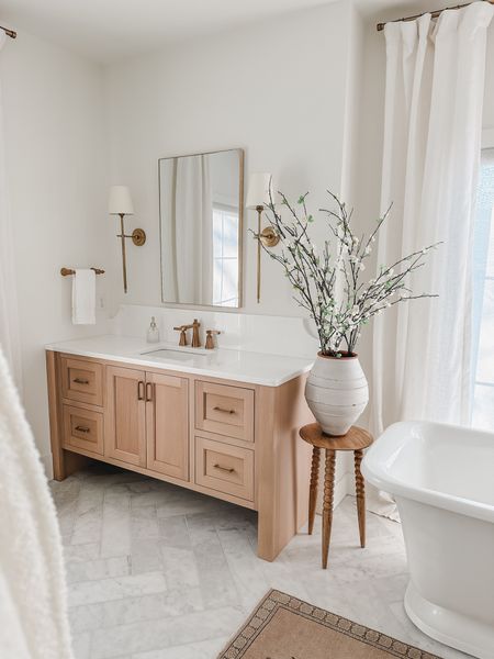 Light and bright primary bathroom with creamy whites, neutral wood tones, and oversized florals for a minimal spring look!

Bathroom views, primary bathroom aesthetic, gold detail, lighting details, end table, faux florals, vase finds, Pottery Barn style, Wayfair, Joss and Main, Target, curtain detail, faux linen curtain, light and bright, neutral wood tones, creamy whites, bright and airy, shop the look!

#LTKstyletip #LTKhome #LTKSeasonal