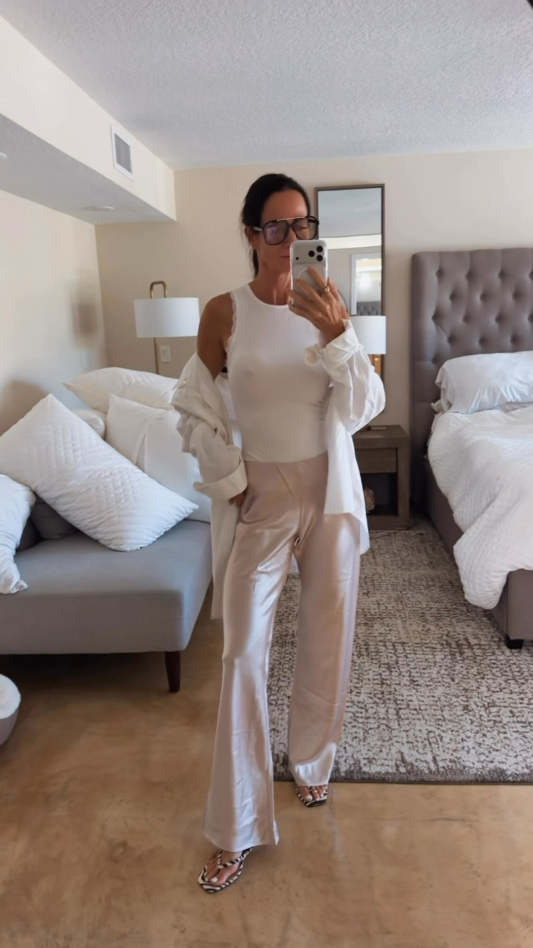 Consider this your reminder that satin pants do not require dinner reservations. 🤍✨

I actually love them MORE styled down.

A fitted white tank + silky satin pants + an oversized button-down thrown over the top = that slightly undone, I didn’t try this hard kind of chic that we’re always trying to achieve. 😉

And can we discuss the little zebra heel moment?? Because apparently an all-neutral outfit still needed a tiny bit of attitude. 🦓

This is exactly how I like to make dressier pieces work harder in my closet — mix the textures, add something casual, and WEAR THE GOOD STUFF.

Wearing XS

#EffortlessStyle #StyleOver40 #EverydayChic #NeutralStyle #SatinPants

#LTKootd #LTKdayinmylife #LTKgrwm