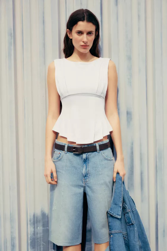 T-shirt made of 100% cotton. Round neck and sleeveless. Asymmetrical hem with pleats. Back metal ... | Zara US