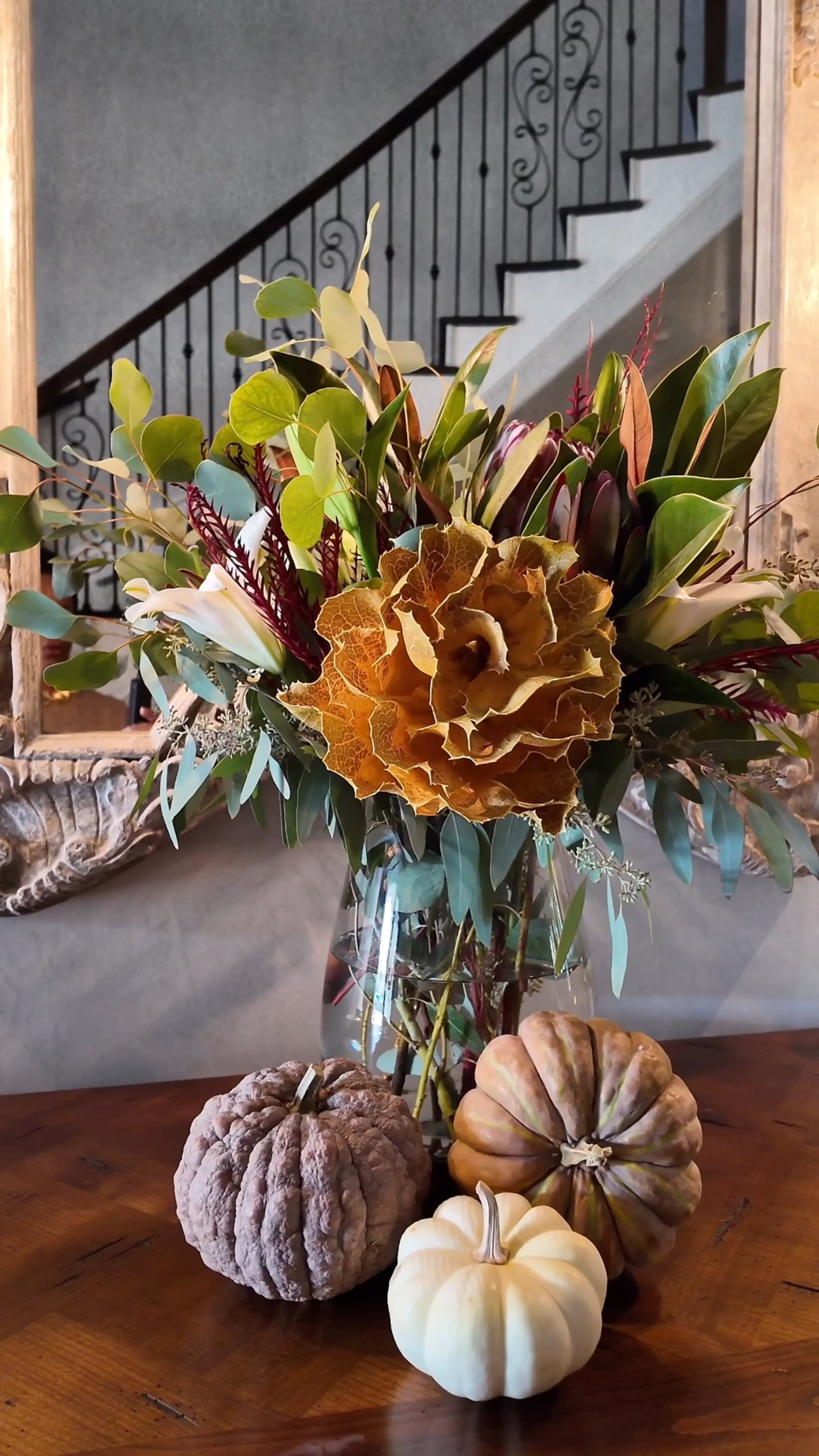 Last-minute guests? No stress! 🏃‍♀️ Here’s my go-to tip for creating an eye-catching centerpiece and setting the perfect vibe. I dashed to Central Market and found some stunning florals—Eucalyptus, cranberry bouquet, white oriental lilies, and the dried Hakea Victoria shrub, which adds a rustic touch, especially with mini pumpkins at the base. 🍂 But here’s the secret: the atmosphere isn’t complete without a warm and inviting scent. I always prefer the cozy allure of candles over diffusers, and for this moment, I chose Yuletide Balsam Whisper by Pivotal Moments. Its blend of amaretto, balsam, and dark musk fills the room with a woodsy, comforting warmth that allures people into my home, making it feel like the ultimate cozy fall retreat. 🕯️✨ 

#CozyFallVibes #PivotalMoments #HomeStylingTips
#florals
#homedecor

#LTKVideo #LTKSeasonal #LTKHome