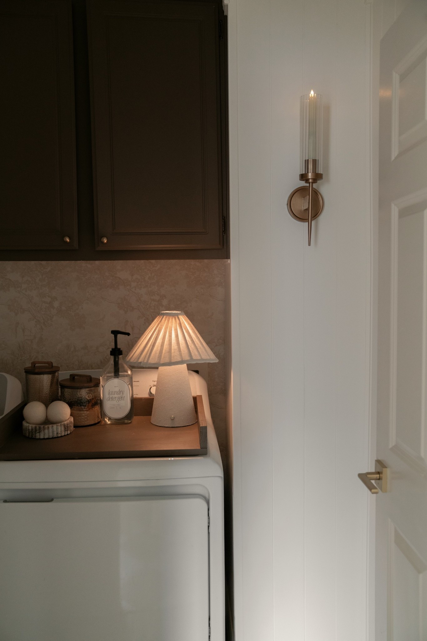 This little laundry room has become one of my favorite spaces in the house.
I linked the wallpaper and hardware on LTK — the cabinets are Northwood Brown by Benjamin Moore, and the walls are Greek Villa at 50% for that soft, warm contrast.

I made the tray & curtain myself, but it’s hung on a simple magnetic rod, which ended up being the easiest solution in here.
Everything I could link is saved on LTK for you.