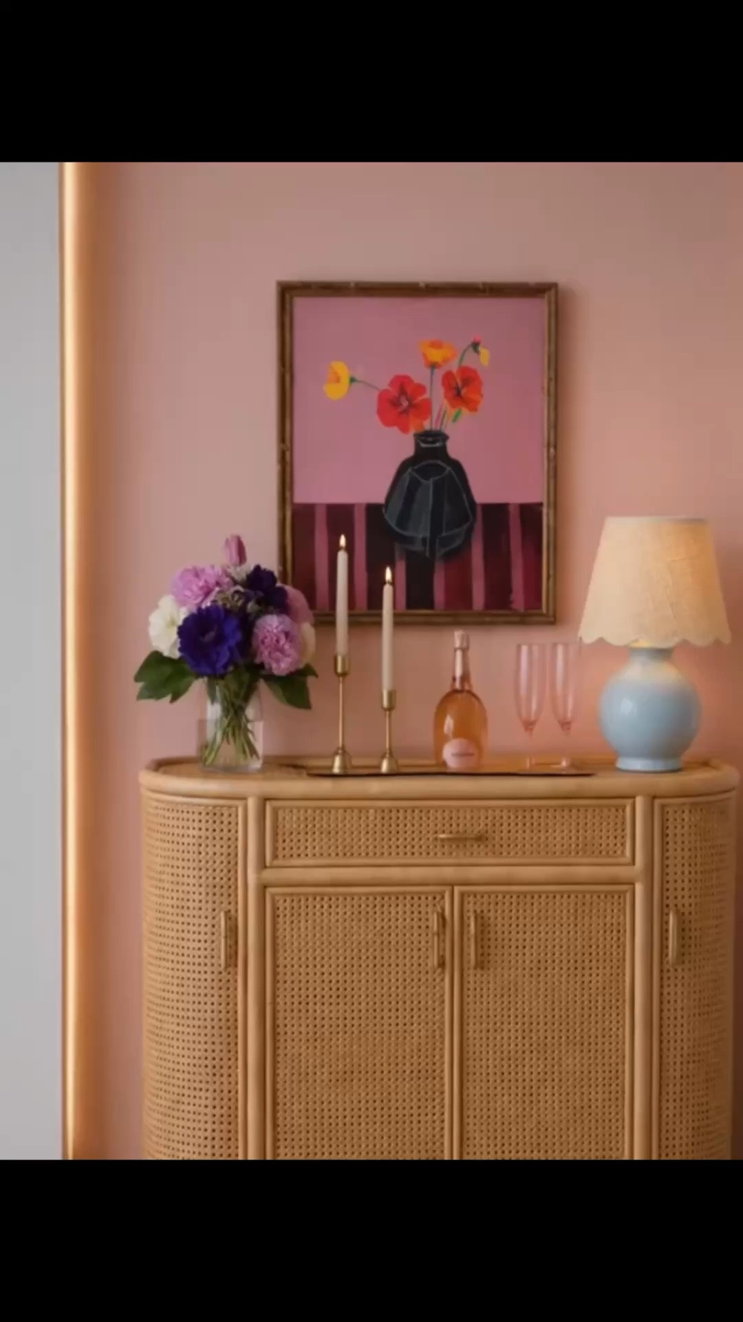 Evening bar station moment. A little blush on the wall softens the whole space, while woven texture, candlelight, and pink champagne set an easy, relaxed mood. A petite bar cabinet can create so much atmosphere without taking much room—perfect for a cozy cocktail corner or a charming after-dinner setup. Loving the layered look of the bar cabinet,  table lamp, brass candle holders, pink flutes, floral art, and soft blush wall color.

#BarCabinet #BarStation #HomeBar #TableLamp #RechargeableTableLamp #CandleHolder #PinkChampagne #FlutedGlass #FloralArt #Wallpaper #RattanFurniture #InteriorStyling #CocktailCorner

#LTKSaleAlert #LTKHome #LTKMothersDay