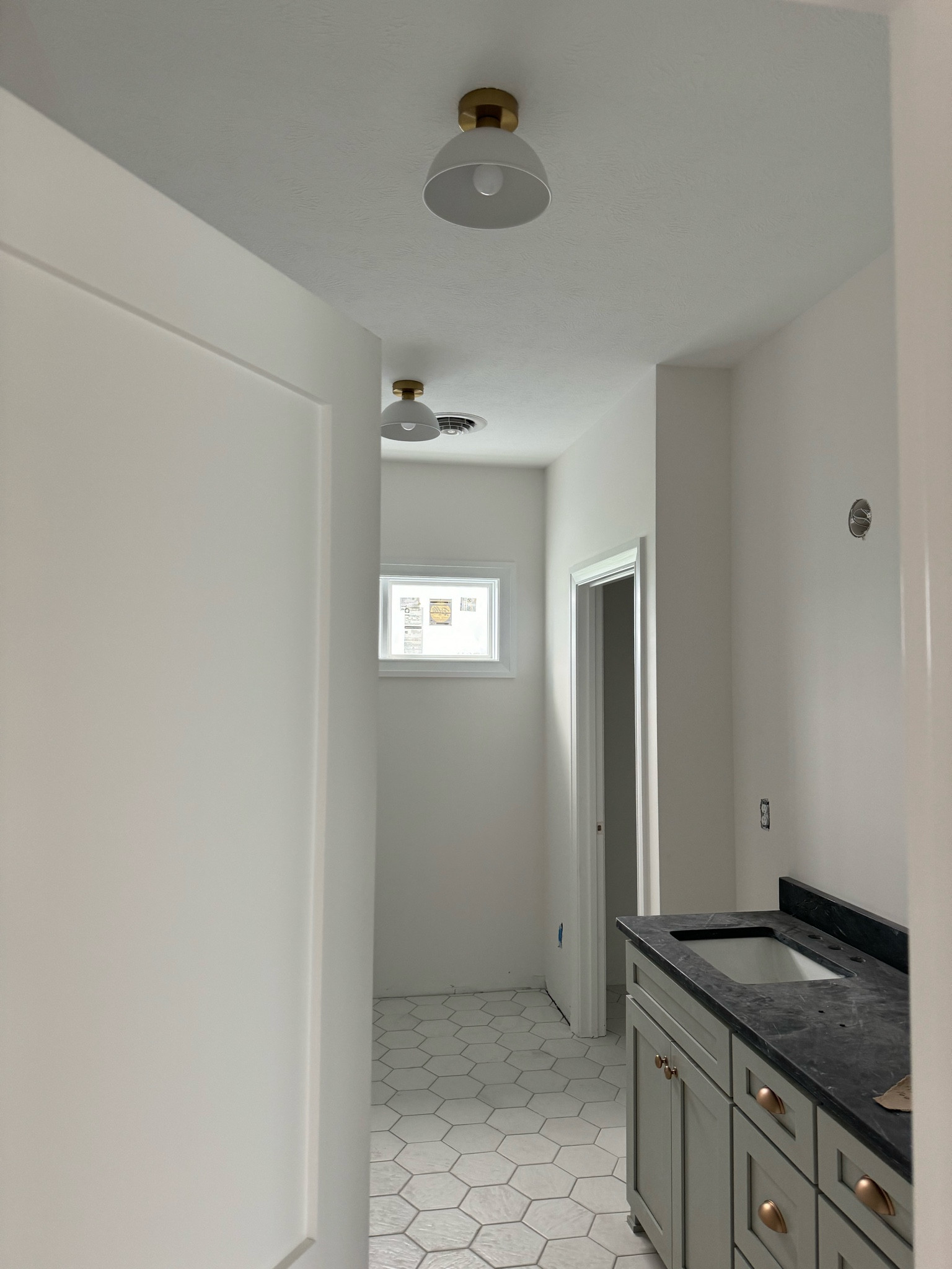 A peek into the hall bathroom of the new home with the ceiling light fixtures installed. 

New build, new home, home build, custom home, lighting, light fixtures, lights, bathroom lights 

#LTKfamily #LTKhome #LTKfindsunder100