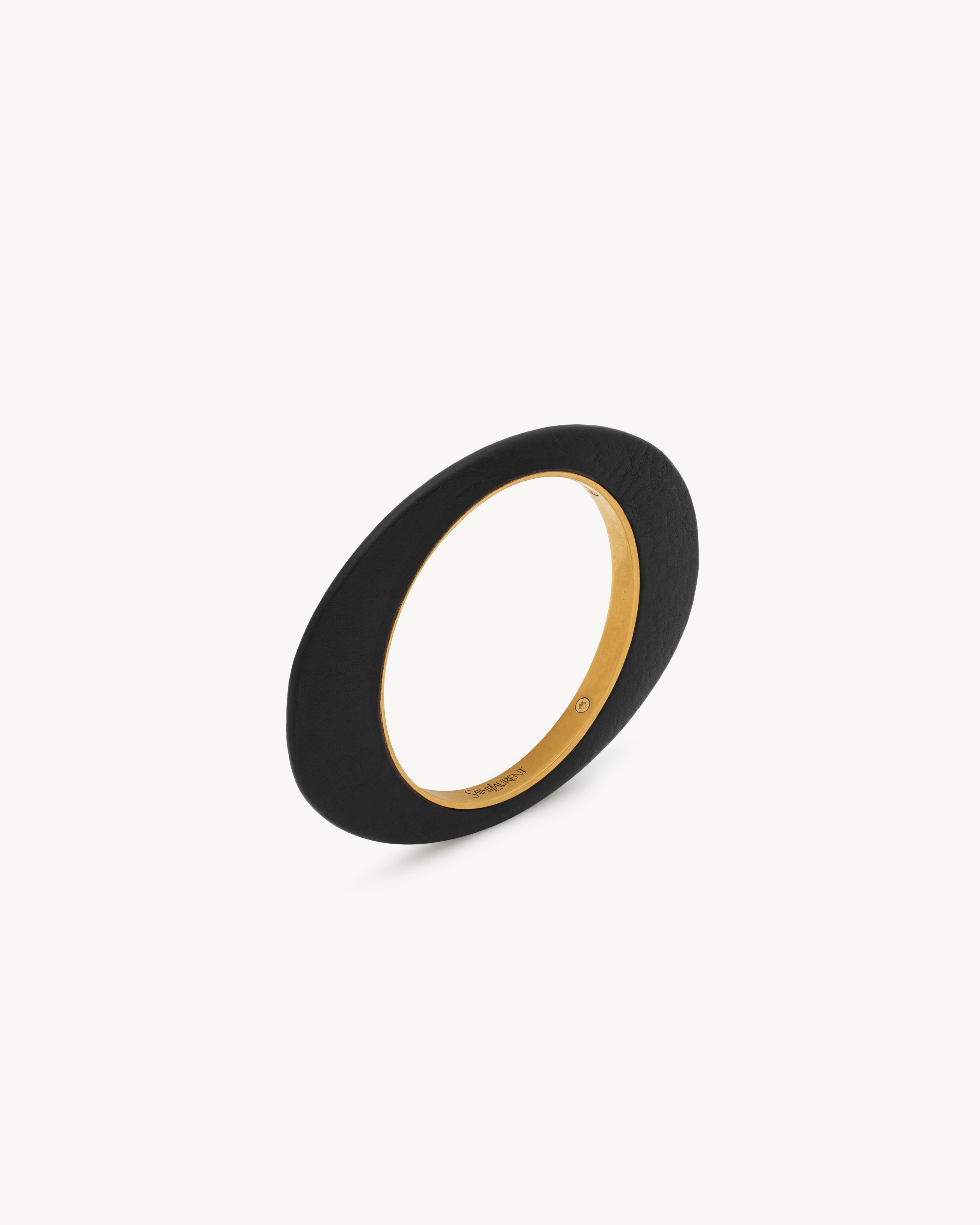 asymmetric leather-covered bangle bracelet with a sharp central ridge, made with vegetable-tanned... | Saint Laurent Inc. (Global)
