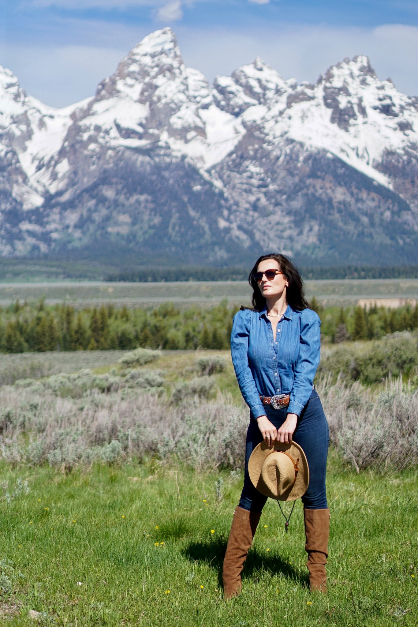 Western-inspired outfit featuring a denim button-down shirt, skinny jeans, and tall suede riding boots. Finished with a straw hat and leather belt, this classic western look is perfect for spring travel, ranch style, outdoor adventures, and casual weekend outfits. 

#LTKTravel #LTKootd #LTKSeasonal