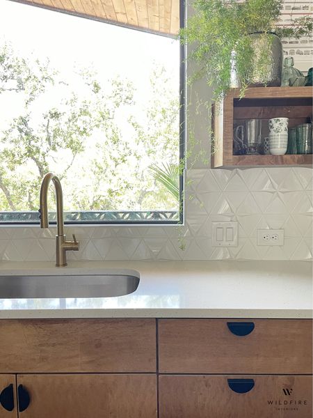 Mid-century style kitchen featuring 3D triangle backsplash tile, gold faucet, flat panel wood cabinets, quartz countertop, and open shelving. 

#LTKhome