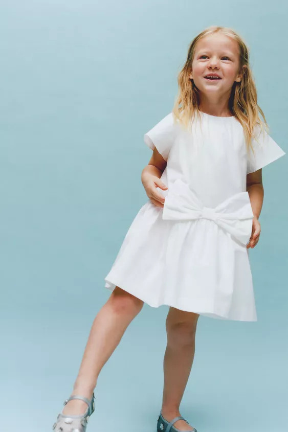 Round neck dress with short sleeves. Buttoned teardrop closure at back. Front bow appliqué. Tona... | Zara US