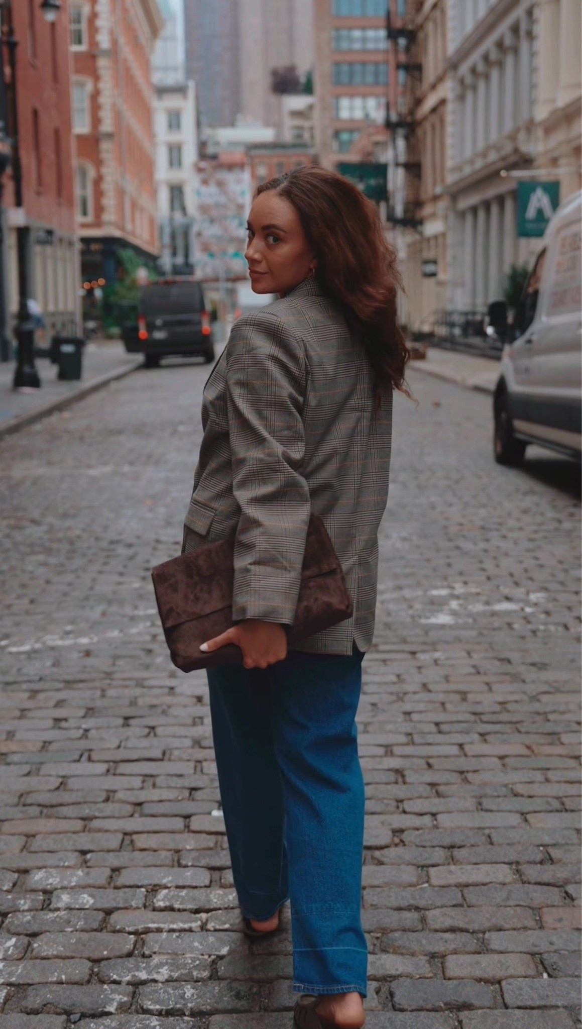 New York Fall outfit Inspo: grey blazer, high rise wide legs jeans, black heels, and a clutch