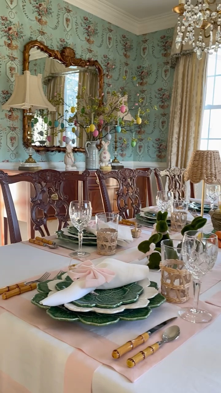 Hoppy first day of Spring, friends! 🌸🐰 How do you sprinkle a little extra magic into this blooming season? I've been busy bunnying up my Easter table with a blend of tradition and whimsy that's sure to make your heart leap. From pink and white linens laying the groundwork for a feast, to green and white tableware with bamboo flatware for that timeless vibe, I'm all in. 🍽✨ Crystal meets rattan in a dance of sophistication, while gold leaf lamps cast a chic glow. And let's not forget the pièce de résistance - each plate crowned with a napkin in a pink bow, flanked by moss green bunnies in pink ties, chirpy chicks, rattan carrots, and a centerpiece that's a basketful of Easter joy. 🐣💐 Over at the buffet, it's a bunny bash among festive branches in a ceramic pitcher, complete with hanging eggs - because if we're doing Spring, we're doing it right! 🌿🎀

#LTKhome #LTKSeasonal #LTKVideo