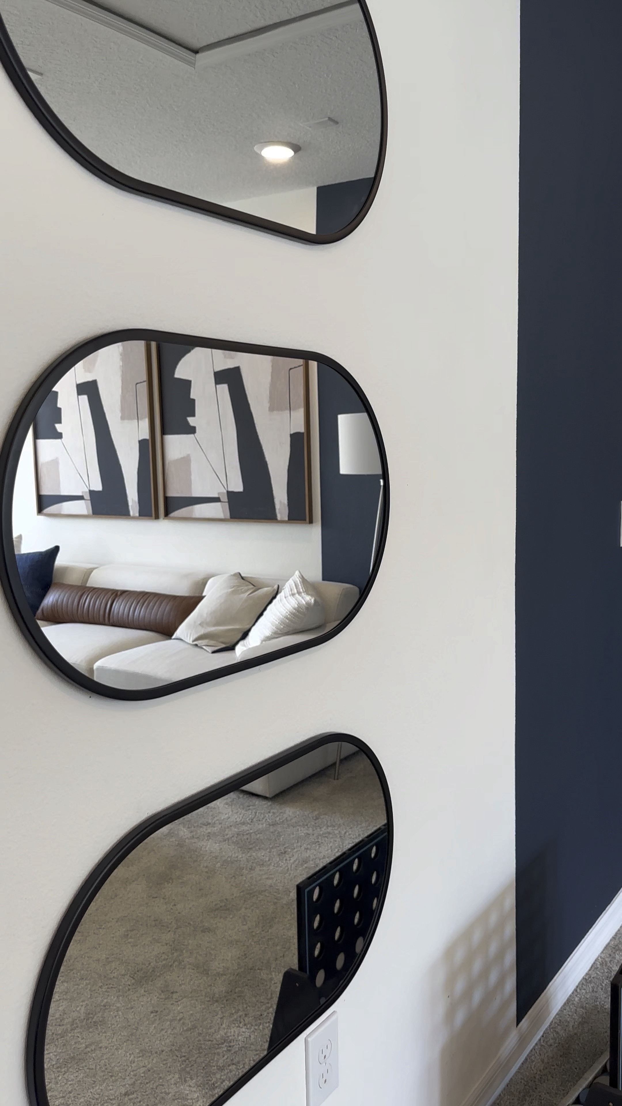 Moody small Living Space in Blue and White Design.  Neutral sofa with two toned Navy and White painted walls, mirrors, and lamp.

#LTKhome #LTKVideo #LTKstyletip