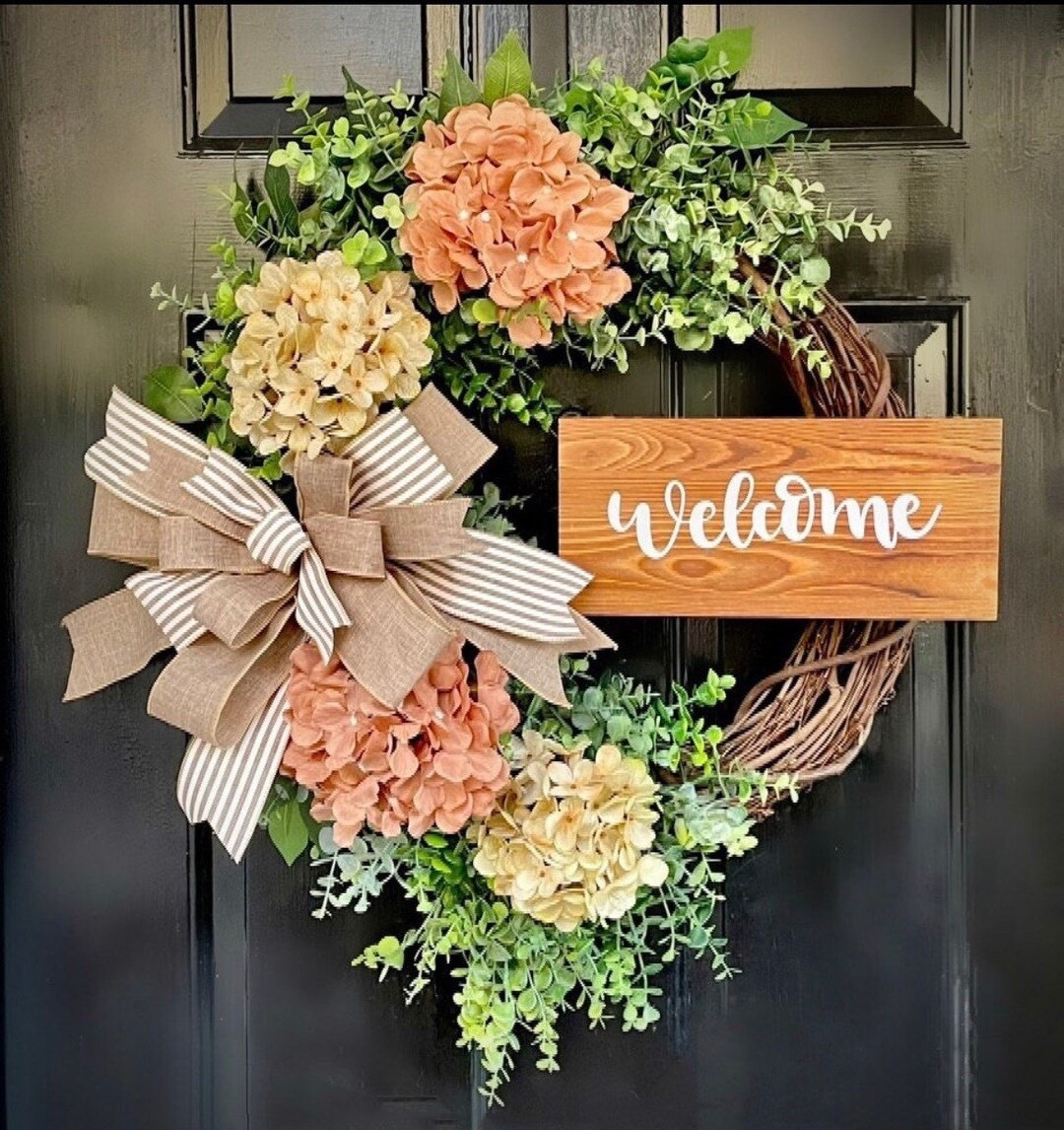Add timeless farmhouse charm to your front door with this beautiful grapevine wreath featuring sweet toffee and cream hydrangeas, soft eucalyptus greenery, and a rustic wood welcome sign. The neutral palette makes it perfect for year-round decorating, while the designer bow adds a warm, inviting touch. Lightly scented with natural lavender and eucalyptus during the drying process, this handcrafted wreath creates a cozy, relaxing feel the moment guests arrive. A classic piece that works beautifully for entryways, porches, or as a thoughtful housewarming gift.

#LTKHome #FarmhouseDecor #FrontDoorDecor #WreathDecor #FarmhouseStyle #NeutralHomeDecor #EntrywayDecor #SpringDecor #YearRoundDecor #CozyHome #HomeInspiration #RusticDecor #HydrangeaDecor #EucalyptusDecor #GiftIdeas #LTKFinds

#LTKWedding #LTKSeasonal #LTKHome