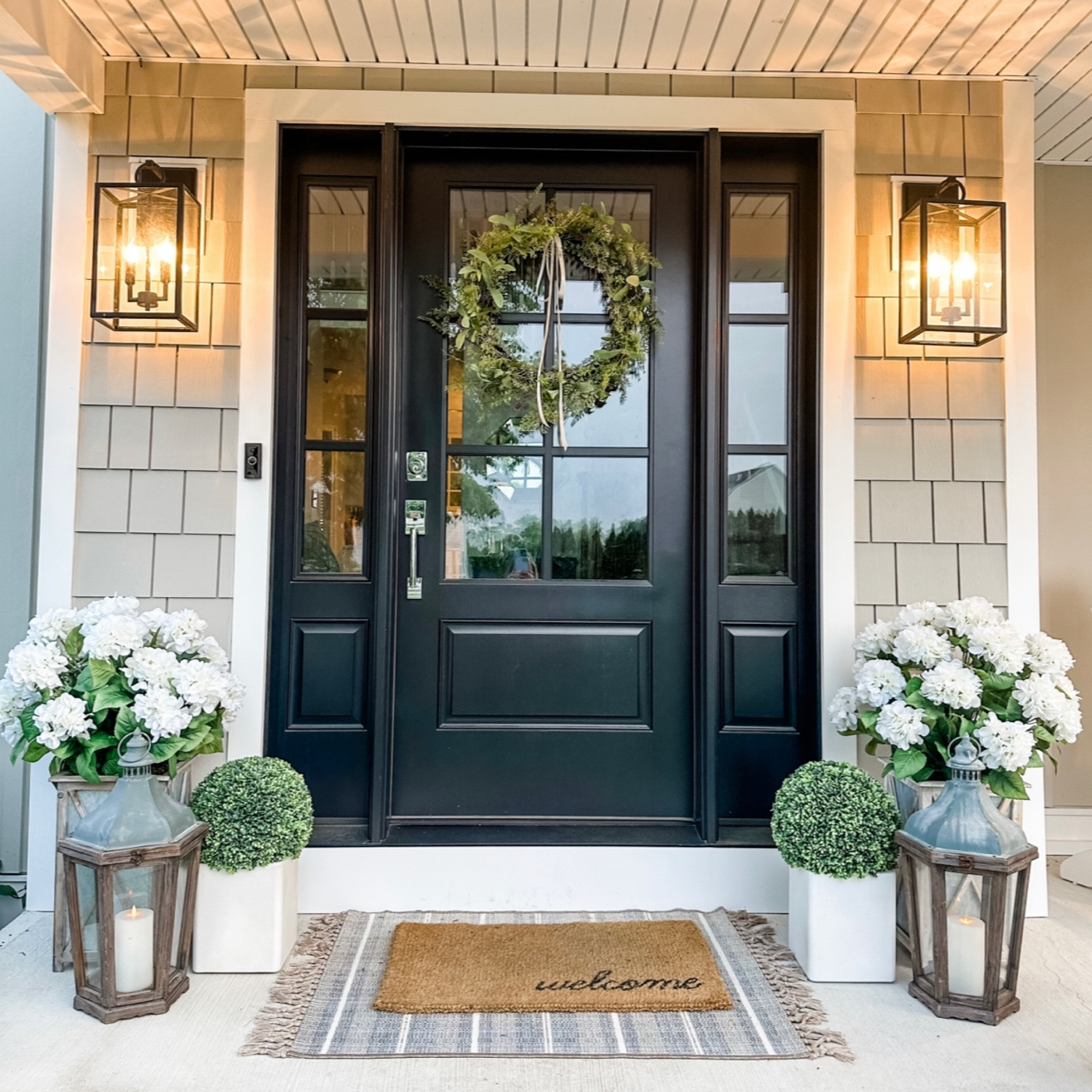 Spring porch 🪻This Studio McGee outdoor rug is only $21! Pictured here is the 30x50 inch which is perfect for layering a doormat on top.

Porch decor, front door decor, outdoor lanterns, outdoor sconces, glass front door, faux hydrangeas, faux boxwood, faux topiary, layered door mat, welcome doormat, Spring wreath, coastal Spring decor, coastal decor, beach house decor, beach decor, beach style, coastal home decor, coastal decorating, coastal interiors, coastal house decor, beach style, neutral home decor, neutral home, modern traditional

#LTKhome #LTKstyletip #LTKsalealert