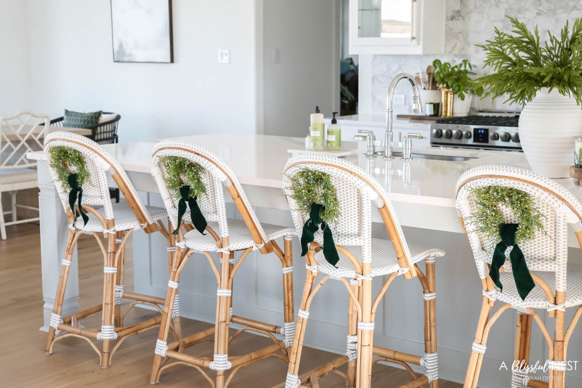 Adding greenery to the bar stools was my favorite Christmas touch in the kitchen. Shop the decor I used here.
 wooden spoons, bamboo dish scrub brushes, Mrs. Meyer's kitchen set, European mill, artificial Norfolk pine branches, suede velvet ribbon, faux juniper wreath, textured ribbed vase 

 #LTKHoliday #LTKSeasonal #LTKHome