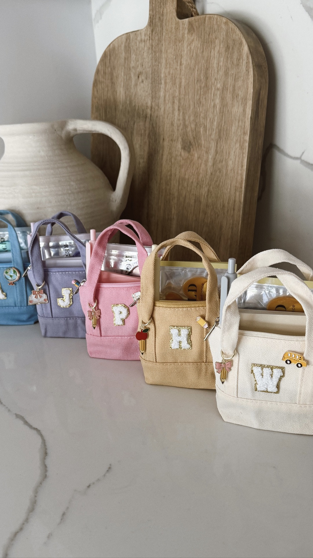 The cutest teacher gift idea ✏️ mini canvas tote key chains 🥲 fill them with teacher goodies like pens, notepads, sanitizer, lip gloss, gift cards, eye patches, etc! Used earrings as the “pins” & “charms” ✨

#teachergift #teacher #backtoschool #bts #2026 #firstdayofschool #canvastote #bagcharms

#LTKSeasonal #LTKKids #LTKmomlife