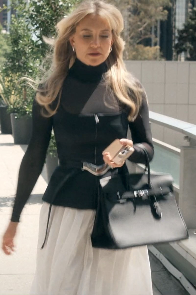 Kate Hudson as Isla Gordon wearing a  Black/White Front-Zip Colorblock Midi Dress, a Black/Silver Leather Belt, and carrying an Hermes Black Leather Birkin Bag 