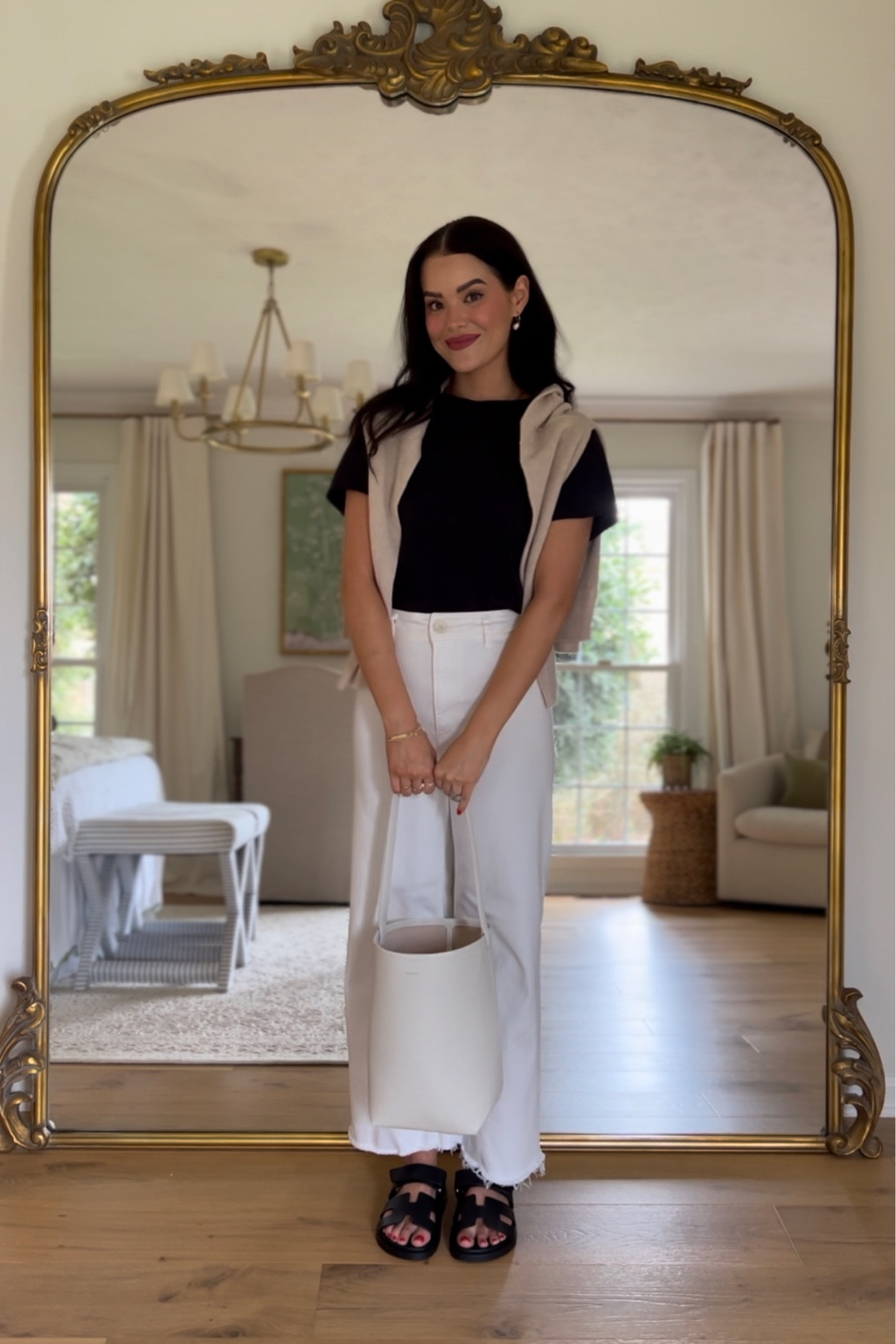 Black t shirt / white wide leg denim jeans / cashmere sweater / black Hermes chypre sandals / the row park tote