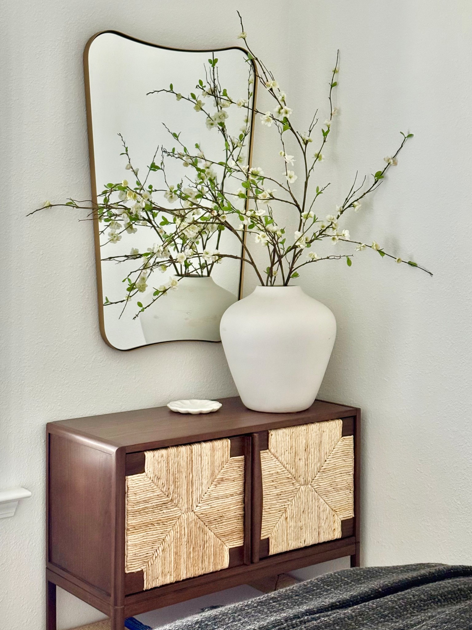 Working on this little corner in our guest room!  Love love this brass Amazon irregular shaped mirror I found for a such a great price!  And of course I used my favorite blooming stems in a white vase!

Home decor, bedroom decor, living room decor, white vase, marble petal bowl, cane front credenza, studio McGee for Target, entryway decor, faux florals 

#LTKSeasonal #LTKHome #LTKSaleAlert