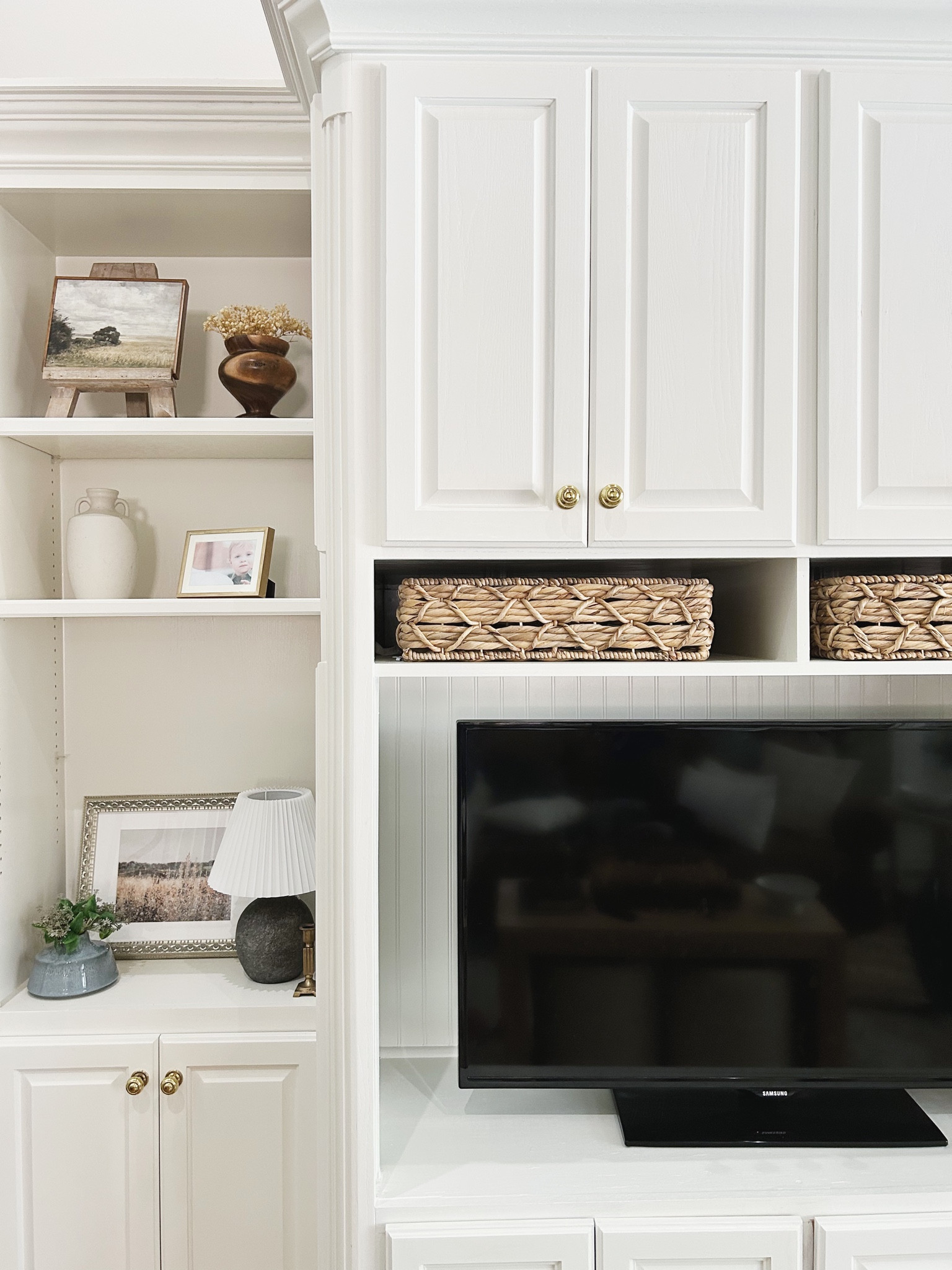 Our living room cabinets. We had these odd shaped rectangular cutouts that open up to the hallway behind the cabinets. I needed baskets to fill the space and these are perfect! Linking what I can from this photo. 

Built in shelf decor, built ins, built in decor, built in shelves, transitional home, transitional home decor, living room decor, white living room, white cabinets, living room inspo, living room design, living room ideas, living room art, living room wall art, Amazon living room, Amazon home, Amazon home decor, Amazon finds, wall art living room, living room cabinet, livingroom decor, wall decor living room, eclectic home, gray living room, grey living room, home living room, home decor living room, Amy Leigh life, beadboard, living room layout, living room lamp, accent lamp, minimalist living room, organic modern living room, neutral living room, living room shelf decor, traditional living room, living room wall, framed wall art, framed wall artwork, budget finds, budget home, budget friendly art, framed art, framed canvas, picture framed, Amazon wall art, landscape art, art artwork, white vase, white vases, flower vase, vase with handles, vase decor, spring stems, wood vase, pleated lampshade, pleated lamp shade, baskets, woven baskets, storage baskets, wicker baskets, 

#amyleighlife
#livingroom

#LTKstyletip #LTKFind #LTKhome