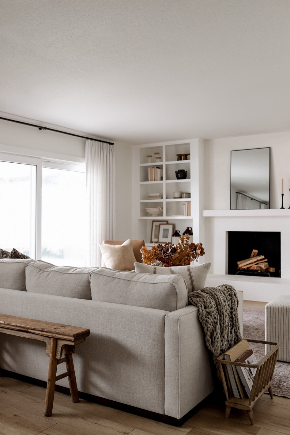 Shop our neutral family room furniture decor! Detouring a gorgeous neutral, performance rug, sleek beige sofa, boucle ottoman, and striped Target ottomans. Loving the fall decor this year!