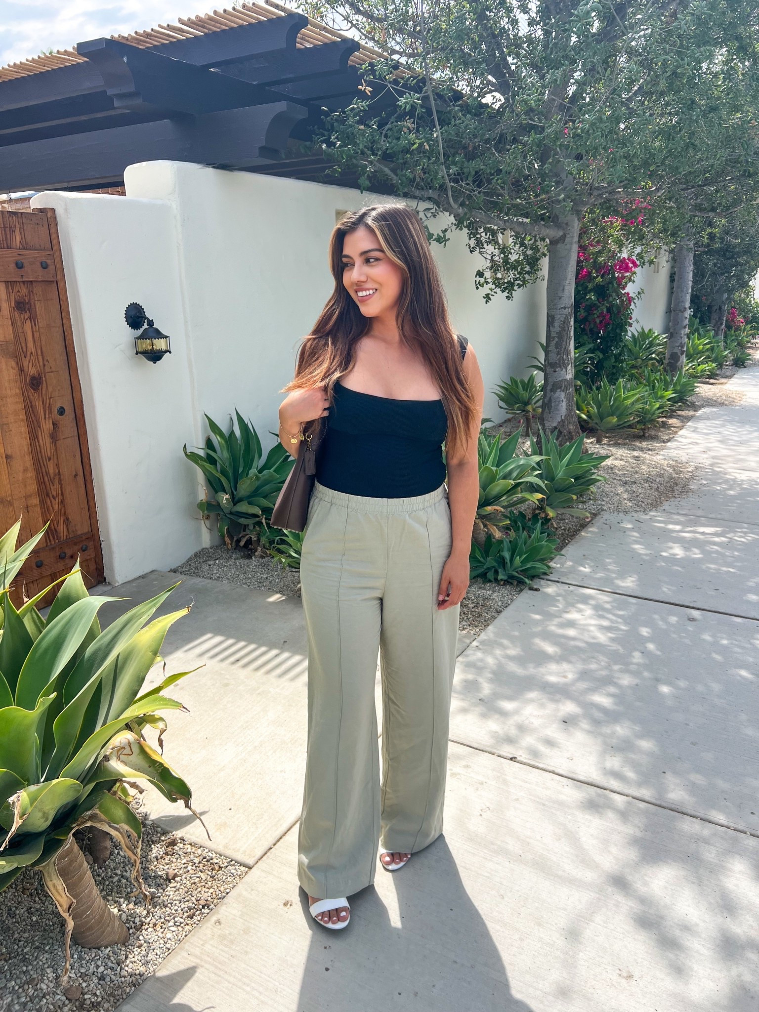 This outfit is chic summer minimalism. Paired the black square-neck tank pairs with wide-leg neutral trousers for an elevated, polished vibe. Pairing with white sandals and a structured bag keep it classy yet relaxed! Perfect for brunch, a vacation stroll, or casual workwear styling—this look is a timeless LTK favorite.

#LTKSeasonal