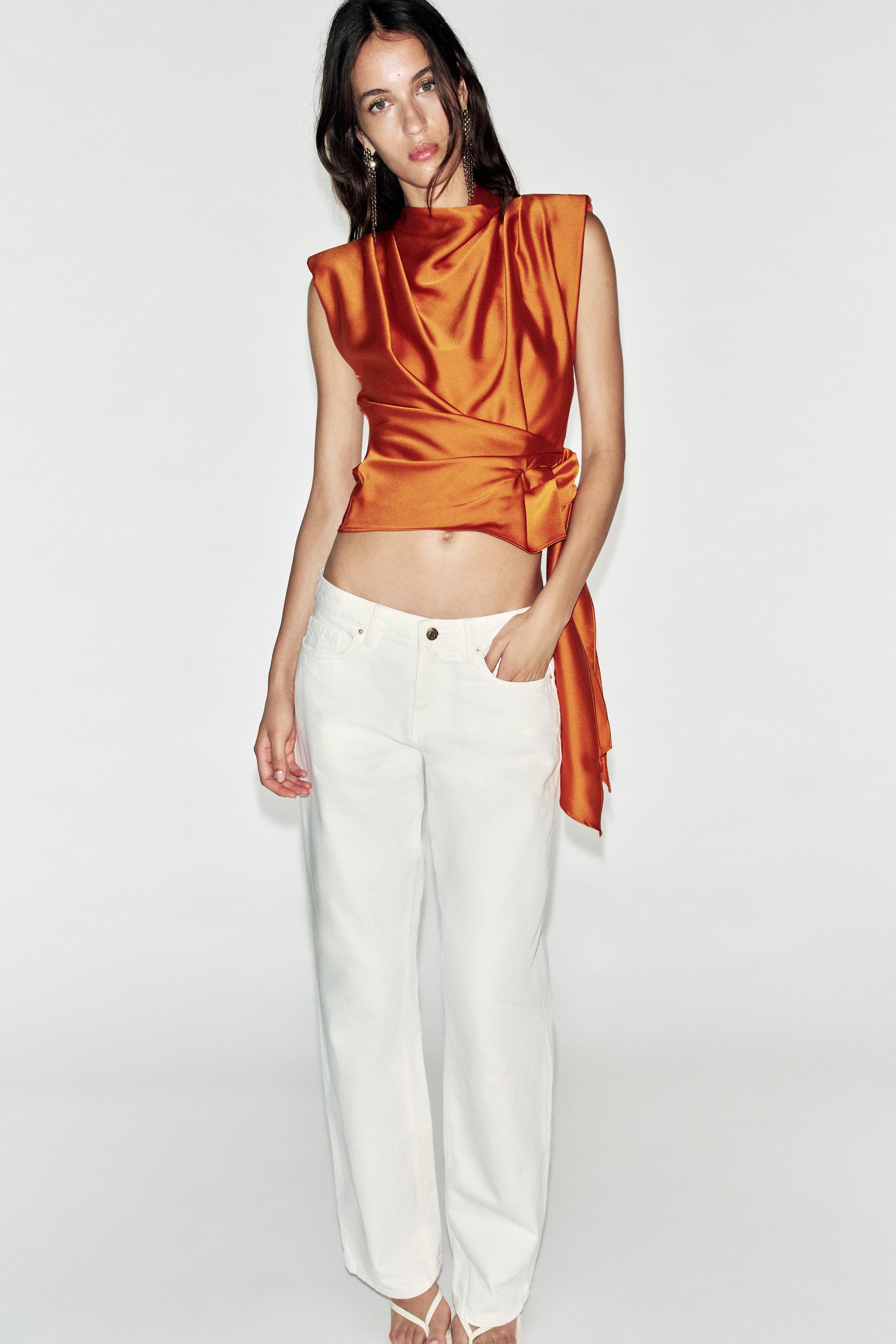 High-neck sleeveless top featuring shoulder pads and pleats. Knot detail at the hem. Back opening... | Zara US