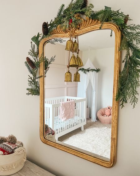 Girl nursery Christmas decor. Gold bells. Christmas decorations. Garland. Toddler girl room. Canopy. Christmas. Mirror. Holiday home decor. 

#LTKHoliday #LTKhome