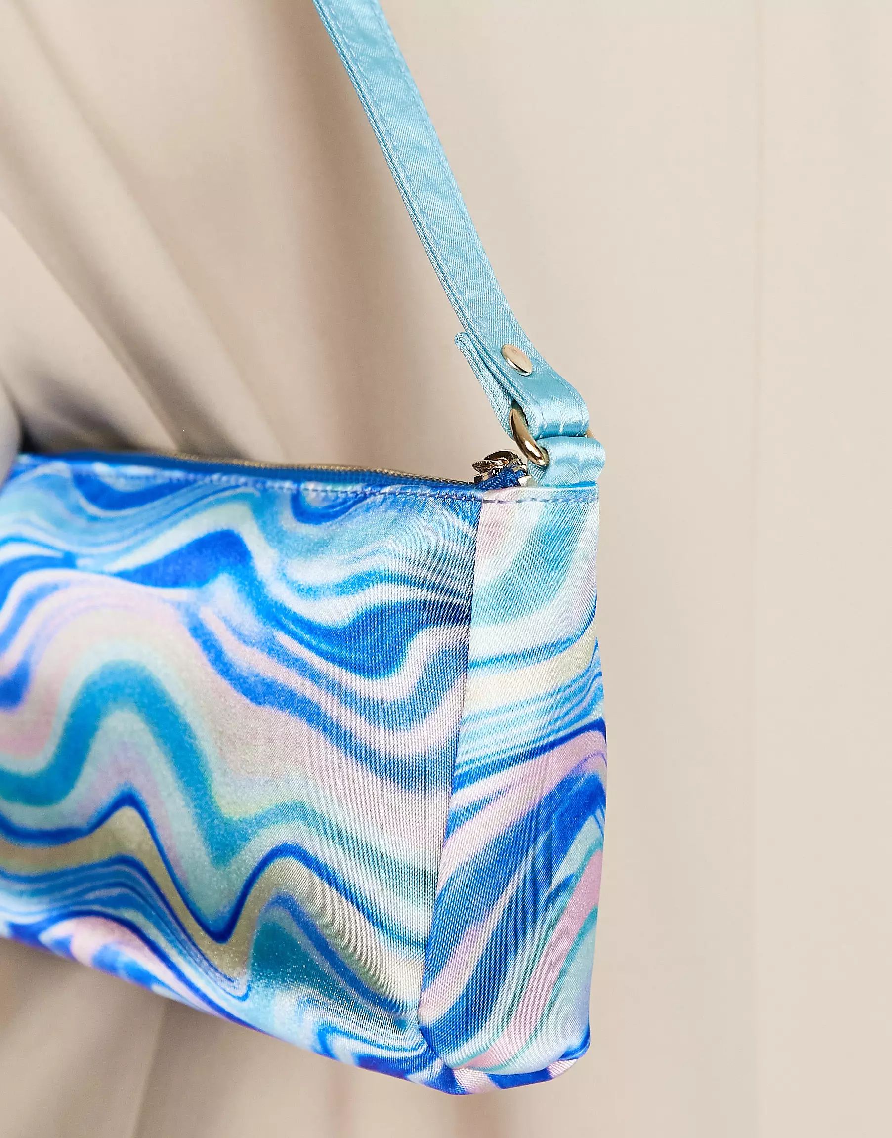 ASOS DESIGN flat elongated 90s shoulder bag in blue satin swirl print window.asos.performance.mar... | ASOS (Global)
