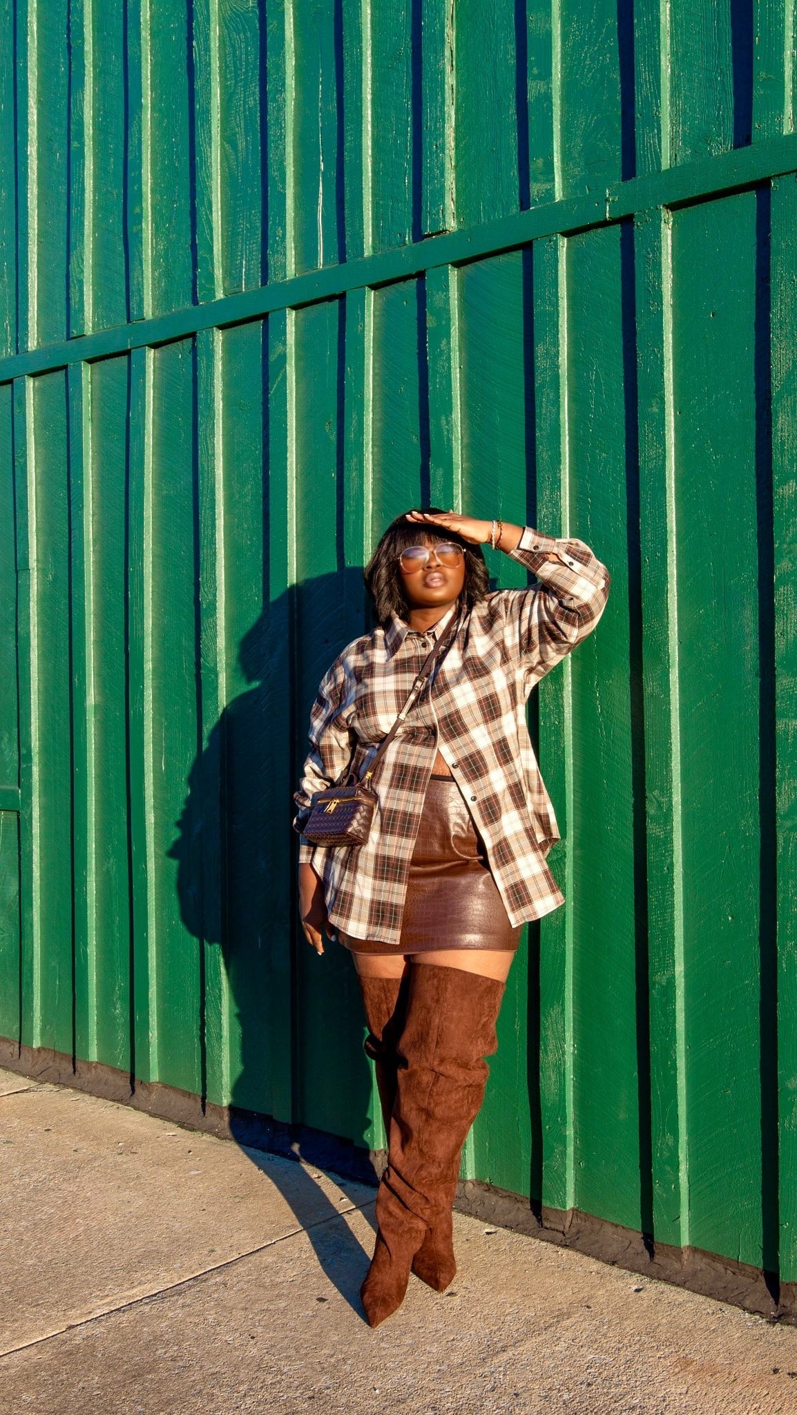 Putting together a fall outfit doesn't have to mean reaching for jeans every time. A plaid button-up layer, fitted brown mini skirt, and knee-high boots create a fun mix of relaxed and structured pieces. The warm brown palette makes everything feel cohesive. plus size fall outfits, plaid shacket outfit, brown mini skirt outfit, suede knee-high boots, chocolate brown fall fashion, curvy fashion inspiration, casual chic fall outfit, fall street style, autumn outfit ideas, how to style a shacket. @amazonfindsandfashion @Torrid @azalea @ASOS