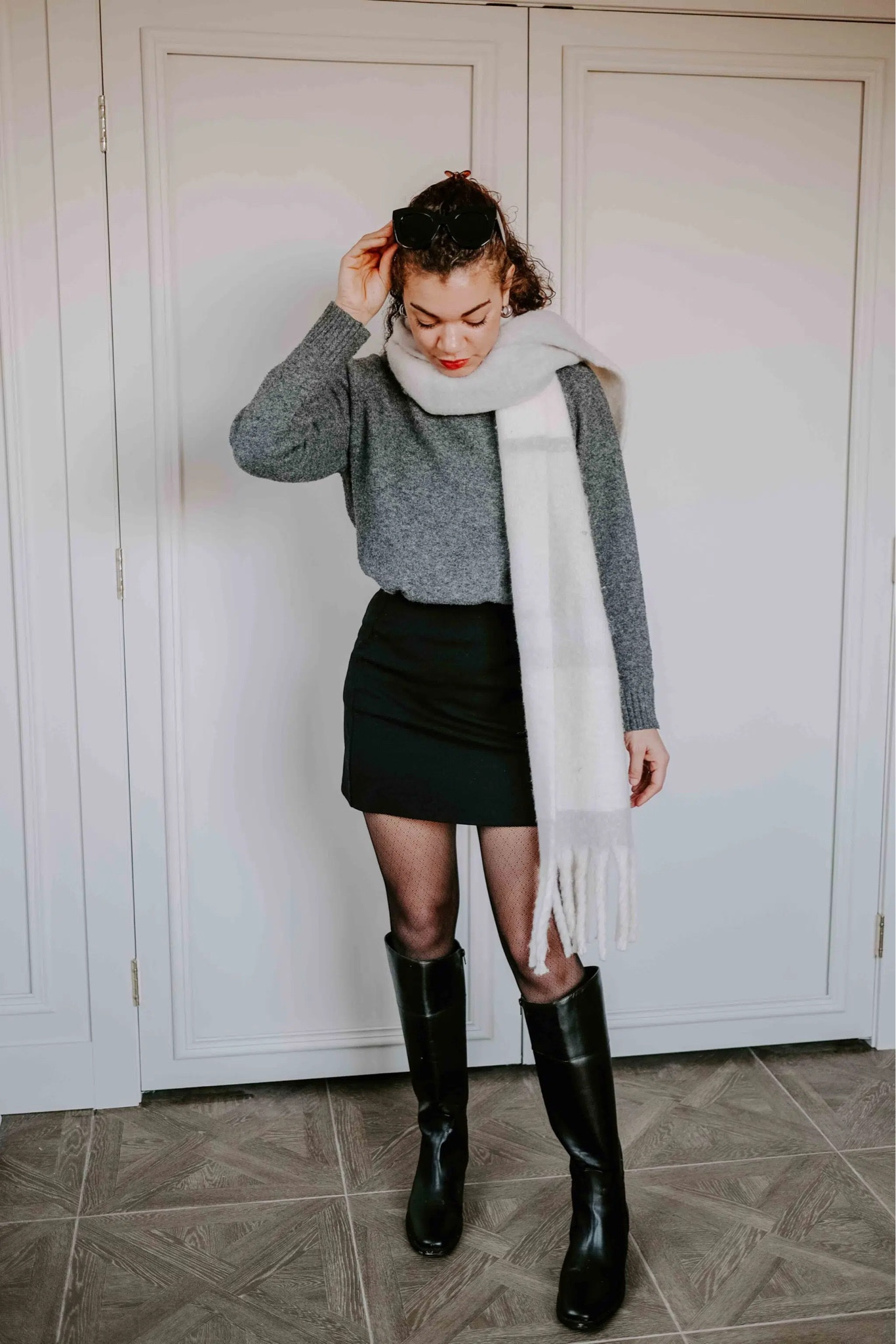 Any mini black skirt works when it comes to learning how to wear riding boots. The shorter length gives the boots an update, while the sheer tights elevate your outfit and add additional coverage.

The oversized scarf adds that current and trendy accessory and complements the other neutrals in the outfit.

#LTKstyletip #LTKshoecrush #LTKSeasonal