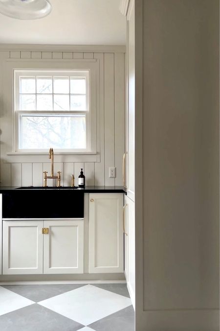 Neutral kitchen renovation with aged brass hardware, brass bridge faucet, and marble checkered floor tiles. #kitchen #kitchendesign #brasshardware

#LTKfamily #LTKhome