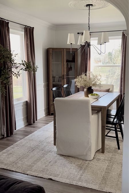 Neutral dining room decor, wooden dining table, black dining chairs, white dining accent chairs, wooden hutch, corner hutch, Two Pages Curtains, Target chairs, dining room chandelier, neutral rug, dining room rug, brown curtains, dining room curtains 

#LTKhome #LTKxTarget #LTKsalealert