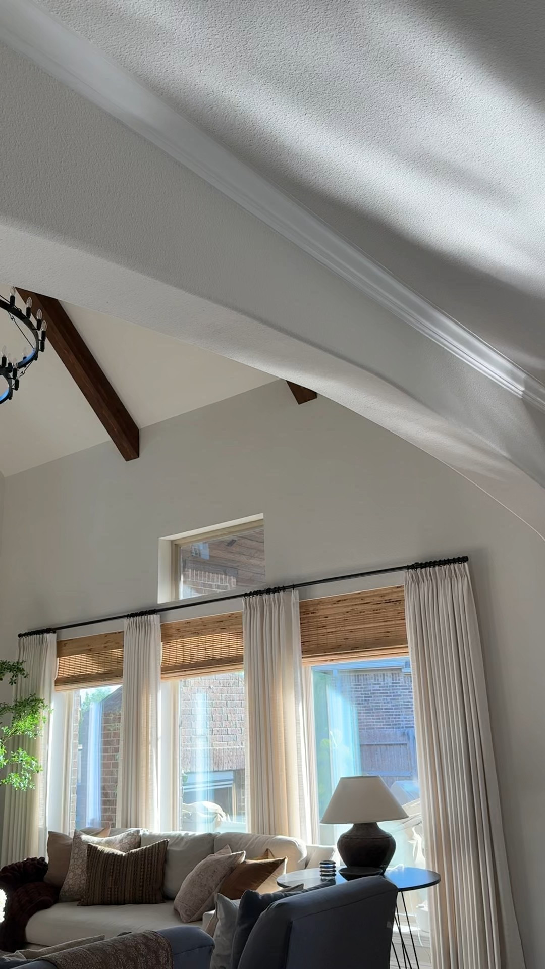 Light linen pleated drapes over bamboo shades, large two tier round chandelier, and faux black olive tree



#LTKHome