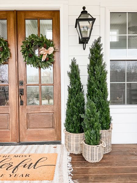 Christmas and holiday front porch front door home decor and styling cedar trees rattan resin baskets double layered oversized doormat and jute scatter rug double entry French doors wreaths with satin ribbon and vintage gold bells outdoor lighting lantern light fixtures wall sconces southern farmhouse modern home decor

#LTKhome #LTKstyletip #LTKHoliday