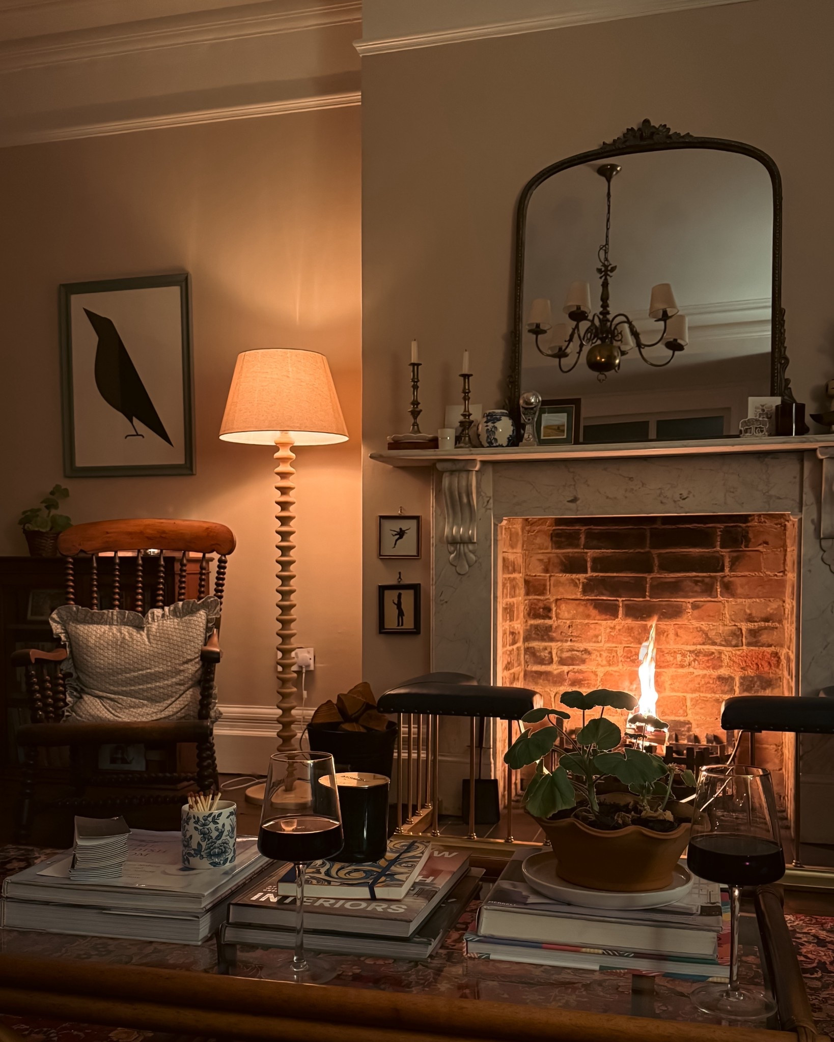 Linking a few items from this room, both exact matches and similar. 

Large overarch mirror - Anthropologie 
Bobbin lamp - Dunelm
Lampshade - Amazon
Very similar art work linked and styling accessories. 

The rug, fireplace fender, bobbin chair and coffee table and secondhand.