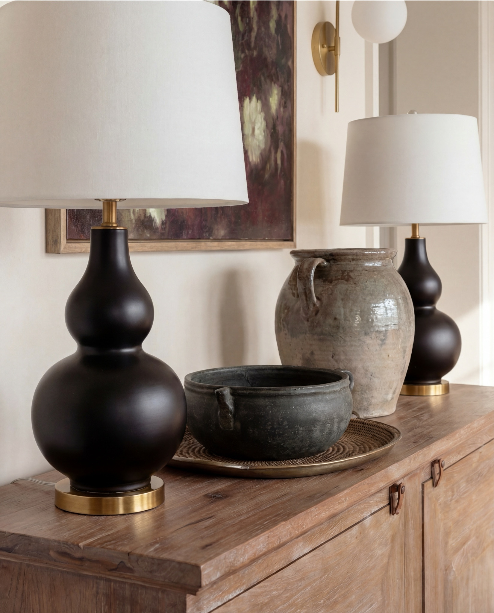 Shop the Look:
• Solid wood dining table (natural oak tone)
• Cane-back dining chairs with upholstered seats
• Upholstered accent dining chair (cream boucle)
• Vintage-style area rug (neutral, muted pattern)
• Exposed wood ceiling beams
• White globe pendant light with brass stem
• Brass wall sconces with globe shades
• Wood sideboard/buffet cabinet
• Black table lamp with white shade
• Ceramic table lamp (neutral glaze)
• Framed abstract artwork
• Glass-front wood hutch cabinet
• White sculptural ceramic bowl (table centerpiece)
• Potted olive tree (faux or real)
• Light wood flooring
• Large windows with simple trim


#LTKHome #LTKSaleAlert