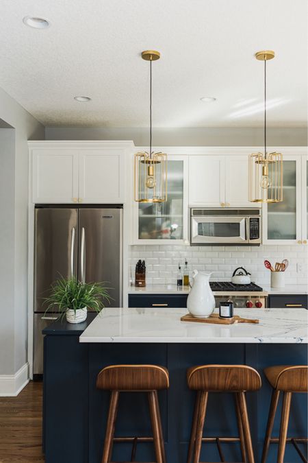 Navy & white kitchen design. 🤍 

Gold mini pendant lights. White beveled subway tile. Faux leather counter stools. Brass cabinet hardware. Cutting boards. White pitcher. Affordable home finds.

#LTKHome #LTKStyleTip