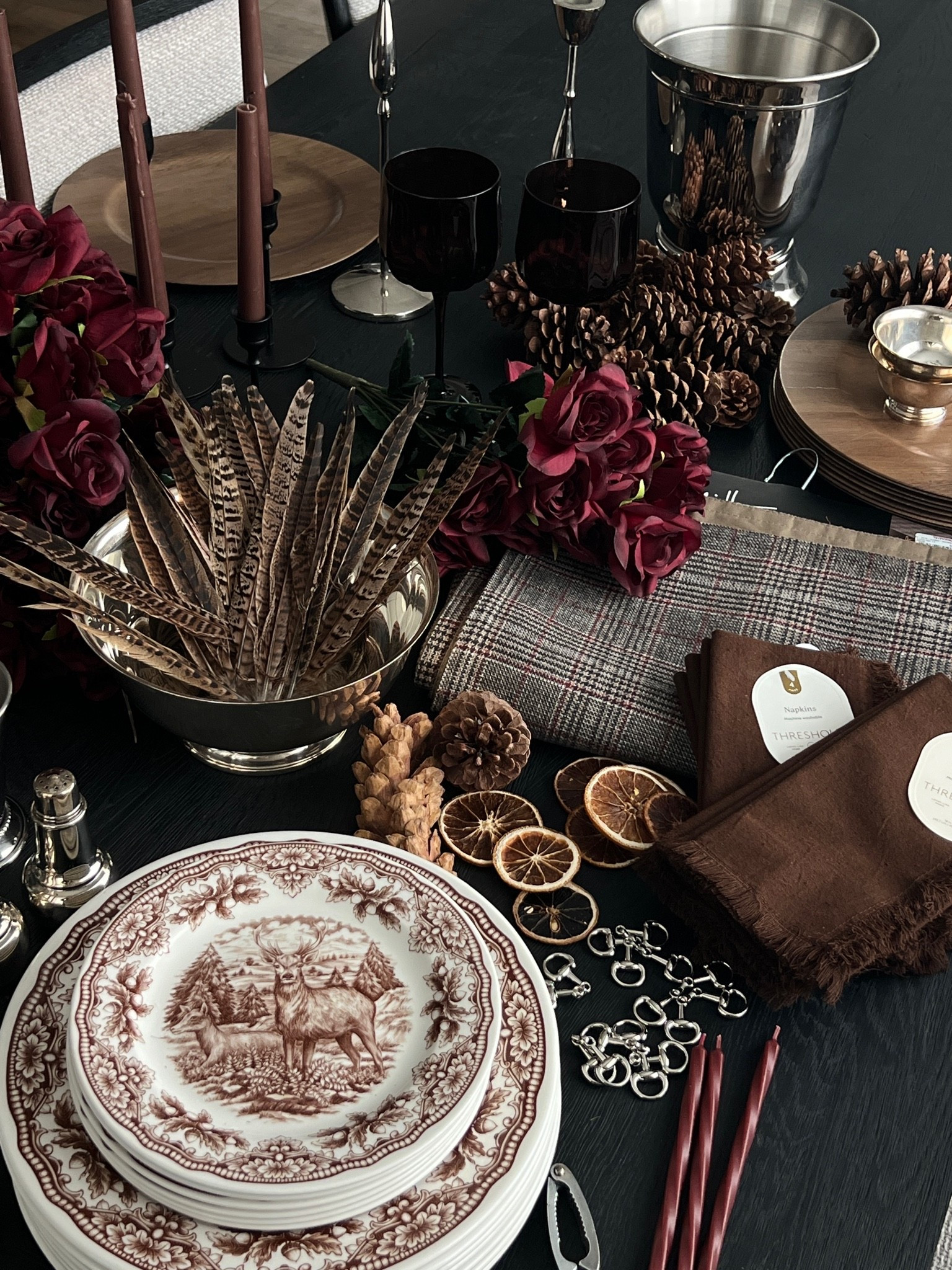 Ralph Lauren inspired fall tablescape, lodge aesthetic, moody fall table decor, classic plaid table linens, plaid napkins, chocolate brown napkins, burgundy roses, brown and white transferware plates, stag plates, woodland dinnerware, wood chargers, silver serving tray, silver centerpiece bowl, silver cups, silver candlesticks, brown taper candles, burgundy glassware, decorative feathers, pinecones, dried orange slices, equestrian inspired decor, rustic elegant table setting, cozy fall dining room, autumn centerpiece, fall hosting essentials, Thanksgiving table inspiration, collected table decor

#LTKSeasonal #LTKHome