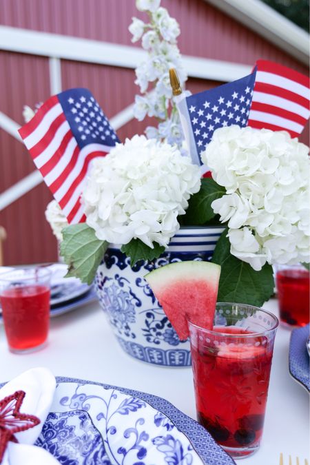 A 4th of July tablescape is the perfect way to celebrate this Independence Day. With the right decorations, you can create a festive and inviting atmosphere for your guests. Add a centerpiece to your table for an extra special touch. Red, white and blue centerpieces can be as simple as an arrangement of candles or as elaborate as a bouquet of flowers. You can even purchase pre-made centerpieces or make one yourself using items such as American flags, star-shaped balloons, and sparklers. For these patriotic table centerpieces, I did a matching blue and white pot from Williams-Sonoma that will double with a plant after the holiday. I filled it with white hydrangeas and small American flags. This was a very simple centerpiece to do and is right on the theme! One thing to be wiery of is hydrangeas get hot and can die quickly because of that, so be sure to purchase the day before or the day off and to spray them with water before taking them outside so they stay plenty wet and hydrated.

#LTKhome