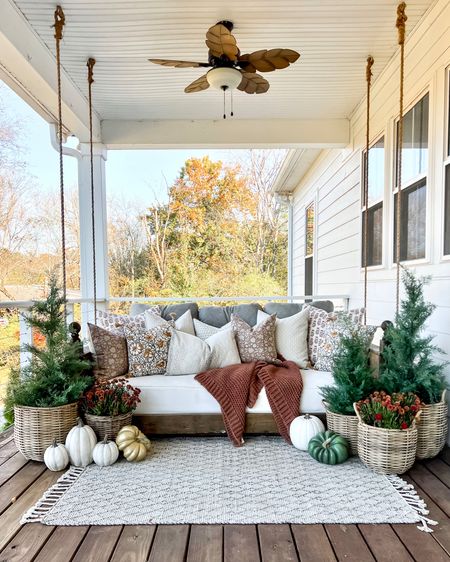 Fall front porch decor Halloween home decor pumpkins mums baskets cedar pine trees faux artificial silk plants and trees throw pillows and blankets porch swing bed swing outdoor ceiling fan furniture and accessories resin planters

#LTKhome #LTKHalloween #LTKSeasonal